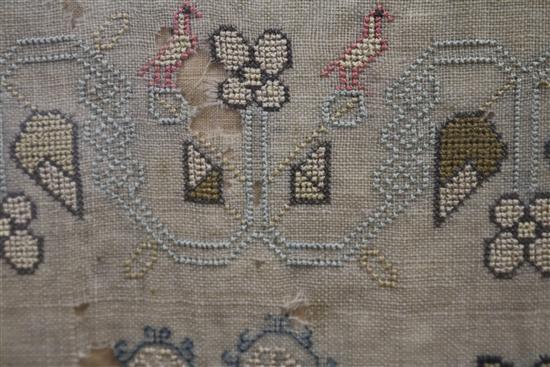 An early 19th century needlework sampler with alphabet, houses, lion, flowers and other motifs, dated 1805, 41 x 31.5cm